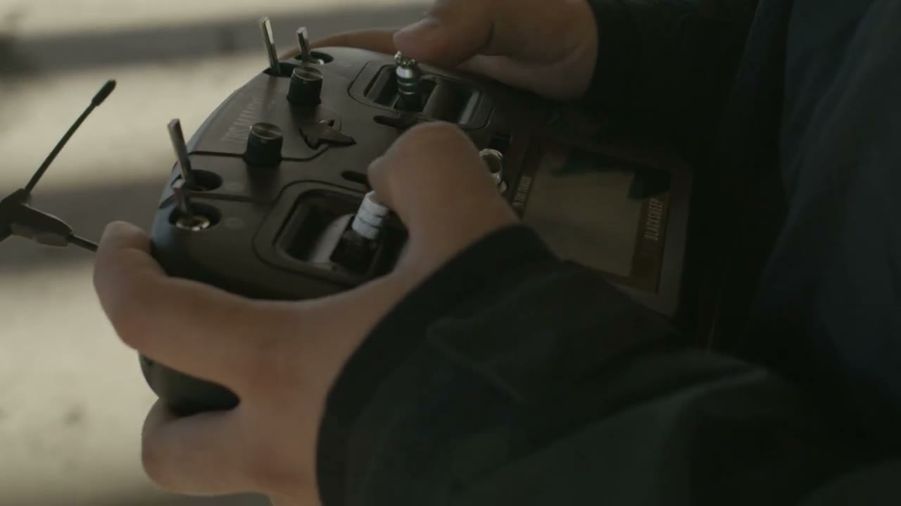 An operator using a controller beside a drone