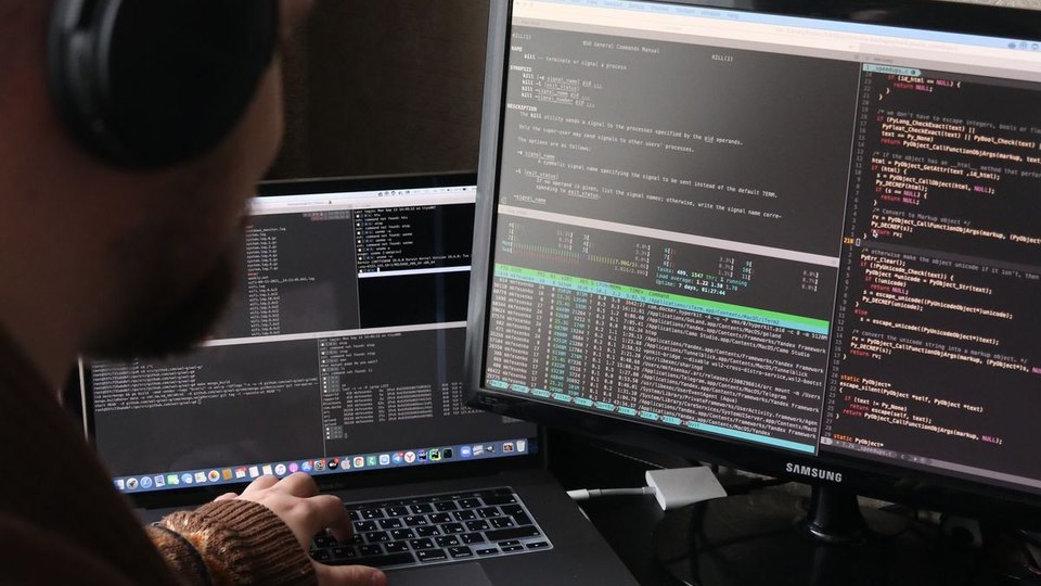 A programmer working at computer monitors