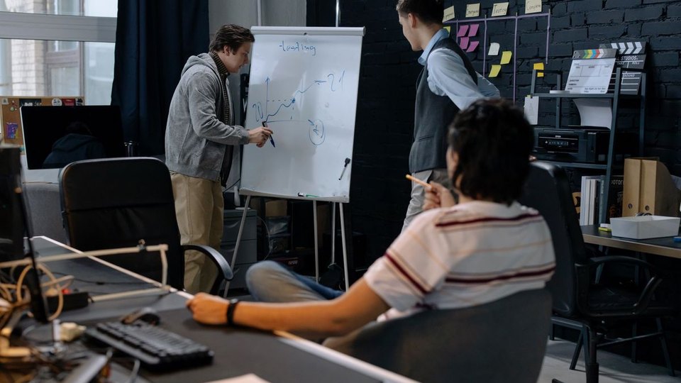 Business team discussing a plan on a whiteboard