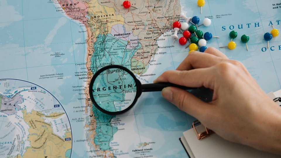 A magnifying glass over a geographical map