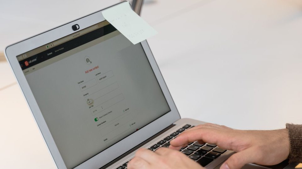 Hands typing on a laptop keyboard