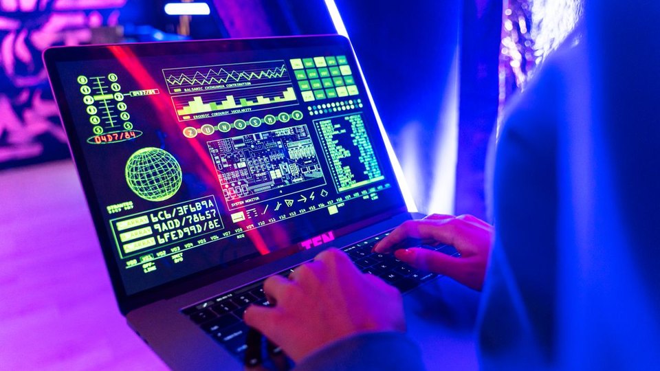 Hands using a laptop with a digital data display