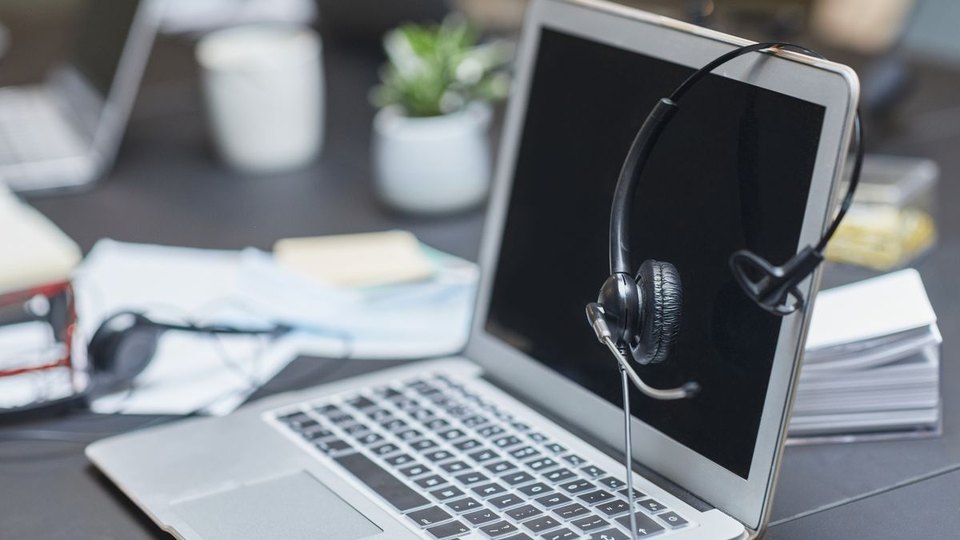 Headset on a laptop in a communication workspace